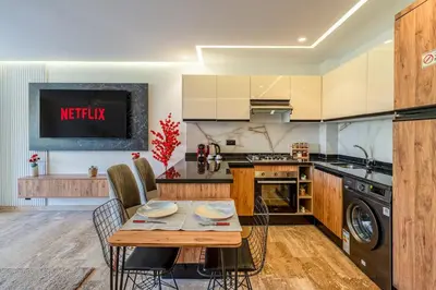 a kitchen with a wooden table and a dining room at Modern 1BR , Balcony & WiFi & 2min Eden in Marrakech