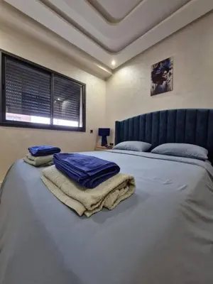 a bedroom with a bed with towels on it at Appartement 3 chambres jaccuzi in Marrakech