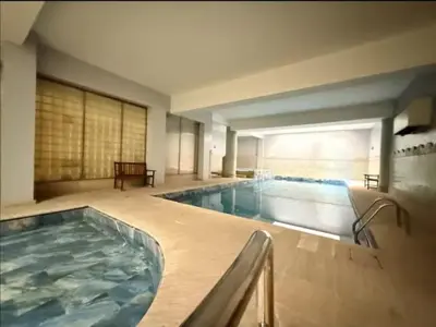 a large indoor swimming pool with a large tub at Maison fati in Marrakech