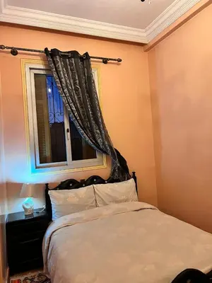 a bedroom with a bed and a window with curtains at Tumsilt in Marrakech