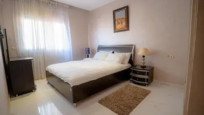 a bedroom with a bed and a window and a lamp at Best Location in Marrakech! Modern Chic Apartment in Marrakech