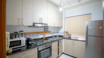 a kitchen with white cabinets and a stainless steel refrigerator at Best Location in Marrakech! Modern Chic Apartment in Marrakech