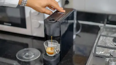 a person is making a drink in a coffee maker at Best Location in Marrakech! Modern Chic Apartment in Marrakech