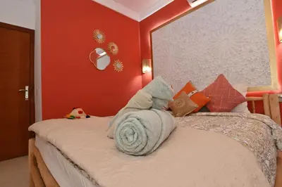 a bedroom with a bed with orange walls at Stylish appartment,5min to airport fiber&netflix in Marrakech