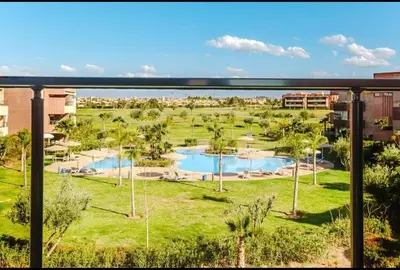 a view from a balcony of a resort with two pools at Appartement 2 chambres a PRESTIGIA piscine in Marrakech