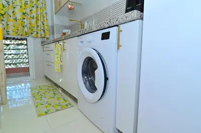 a white washing machine in a white laundry room at Stylish apartment, 5 min to airport fiber&Netflix in Marrakech