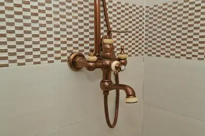 a copper shower faucet in a bathroom at Stylish apartment, 5 min to airport fiber&Netflix in Marrakech