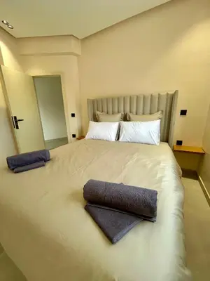 a bedroom with a large bed with two towels on it at Appartement 2 chambres neuf Marjane Rte de Casa in Marrakech