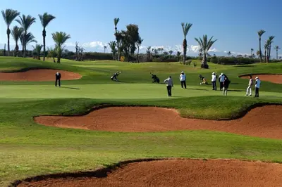 a group of people playing golf on a golf course at Amelkis Golf Villa Prestige Habaïta Marrakech in Marrakech