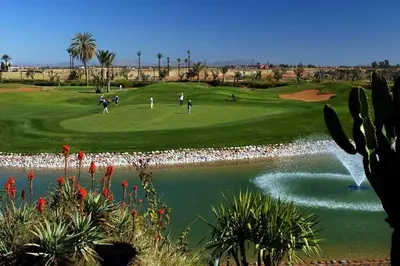 a group of people playing golf on a golf course at Amelkis Golf Villa Prestige Habaïta Marrakech in Marrakech