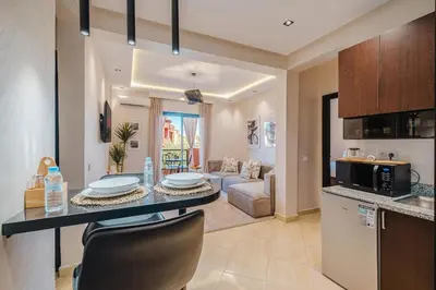 a kitchen and living room with a table and chairs at Appartement Standing Marrakech Caricia in Marrakech