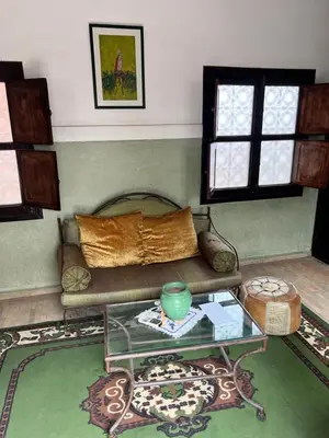 a living room with a couch and a glass table at RIAD Dar Aïlen Médina in Marrakech
