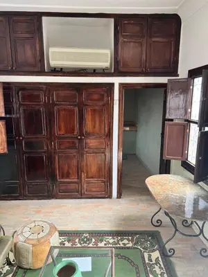 a living room with wooden cabinets and a table at RIAD Dar Aïlen Médina in Marrakech