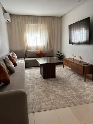 a living room with a couch and a coffee table at Appartement Targa Marrakech in Marrakech