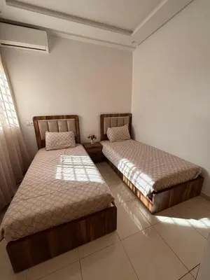 two beds sitting in a room withermottermott at Appartement Targa Marrakech in Marrakech