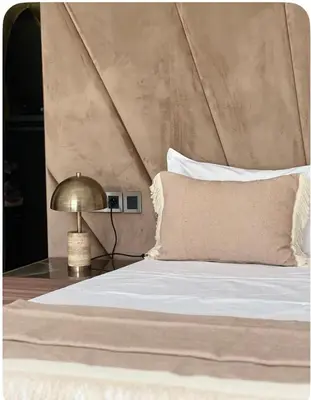 a bed with a pillow and a lamp on a table at Villa Brin d'Olive Marrakech 6 chambres in Gzoula