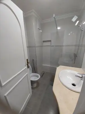 a white bathroom with a sink and a toilet at Studio Elégant Gueliz in Marrakech