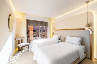 a hotel room with two beds and a window at Appartment - Kasbel 2 - Pools & Spa & Gym Club in Marrakech