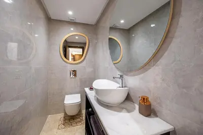 a bathroom with a sink and a toilet and mirrors at Appartment - Kasbel 2 - Pools & Spa & Gym Club in Marrakech