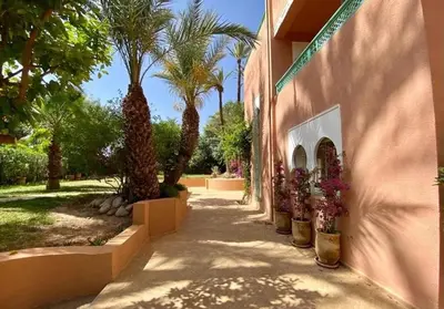 a sidewalk next to a building with palm trees at Grand duplex Palmeraie in Marrakech