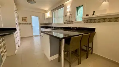 a large kitchen with a large island with bar chairs at Grand duplex Palmeraie in Marrakech