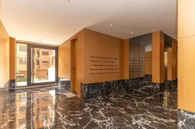 a kitchen with black marble flooring and wooden cabinets at Elite garden Stylish Unique Appartement in Marrakech