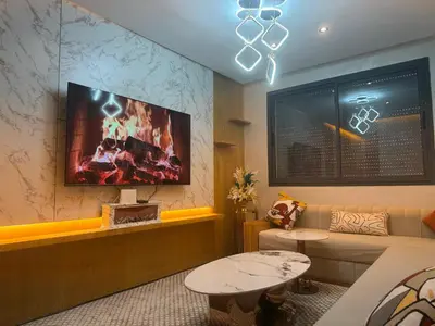 a living room with a couch and a tv on the wall at Elite garden Stylish Unique Appartement in Marrakech