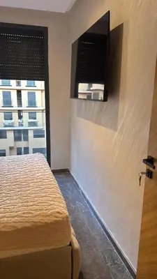 a bedroom with a bed and a window with a television at Elite garden Stylish Unique Appartement in Marrakech