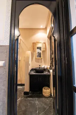 a bathroom with a black sink and a mirror at Riad Bloom in Marrakech