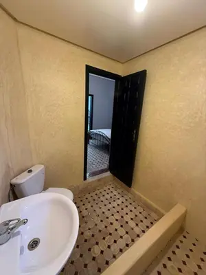 a bathroom with a sink and a toilet and a mirror at Riad Souleimane Résidence Qaria Siyahiya in Marrakech