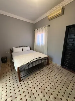 a bedroom with a bed with a checkered floor at Riad Souleimane Résidence Qaria Siyahiya in Marrakech