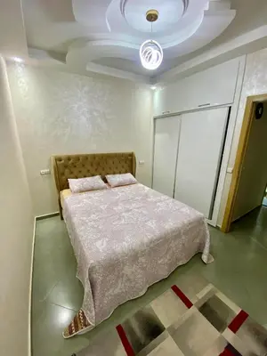 a bedroom with a bed in a room with a ceiling at Charmante moderne Wohnung in der Nähe des Flughafens in Marrakech