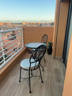 a table and chairs on a balcony with a view at dar nour alhuda in Marrakech