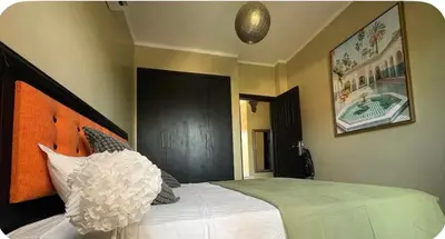 a bedroom with a bed with a large white pillow at Welcome to your Stylish Atlas View Apartment in Marrakech