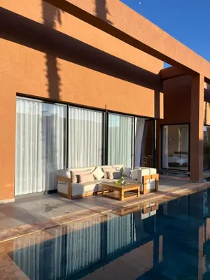 a living room with a couch and a pool at Villa Signature in Marrakech