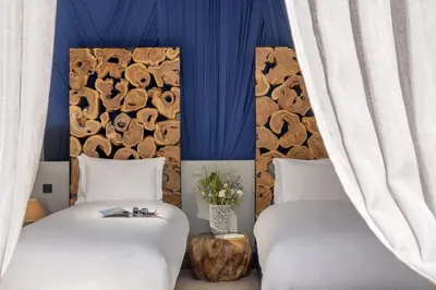 two beds in a room with blue walls at The Source Hotel Music & Spa in Marrakech