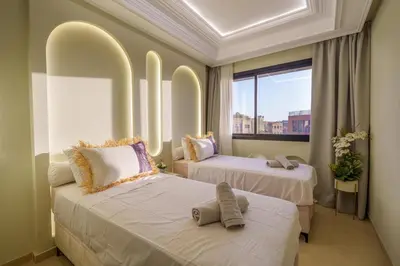two beds in a room with a window at Princess Gueliz center, Comfort, Quiet and View in Oulad Akkou