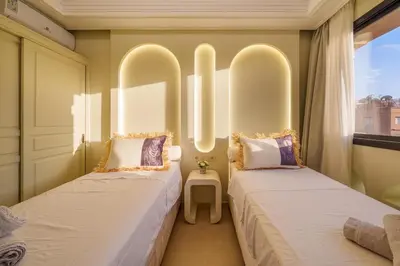 two beds in a room with two windows at Princess Gueliz center, Comfort, Quiet and View in Oulad Akkou