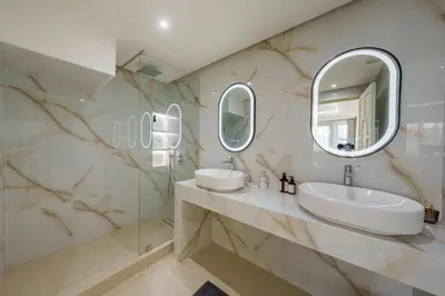 a bathroom with two sinks and two mirrors at Princess Gueliz center, Comfort, Quiet and View in Oulad Akkou