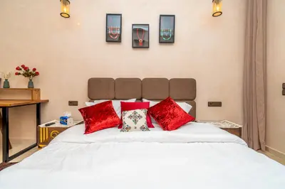 a large white bed with red pillows on it at Appart 2Ch Centre Marrakech in Marrakech