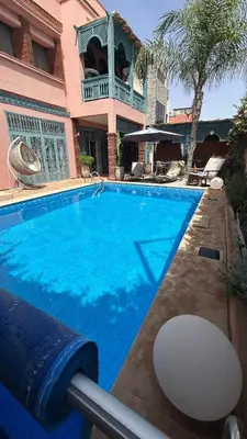 a large blue swimming pool in front of a building at Villa in marrakech city center with heated pool and breakfast inclued in Marrakech