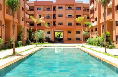 a swimming pool in front of a building at Cozy luxury apartment downtown pool wifi fiber parking in Marrakech