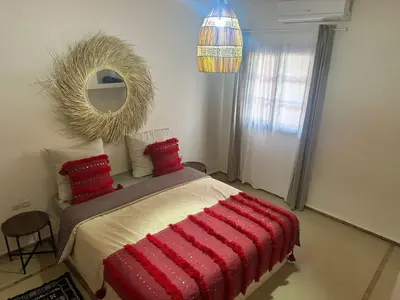 a bedroom with a bed with red pillows and a mirror at Villa Léa in Marrakech