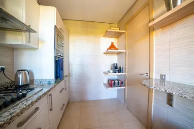 a kitchen with white counters and a stove top oven at Prestigia golf city marrakech in Marrakech