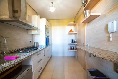 a kitchen with white cabinets and a counter top at Prestigia golf city marrakech in Marrakech