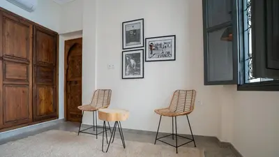 a room with three stools and a wall with pictures at Manzil Fanny Private Riad & Spa in Marrakech