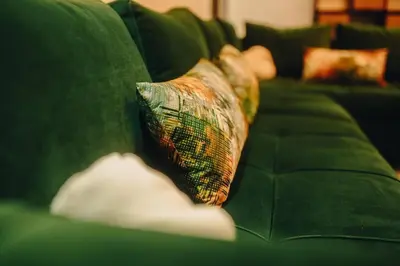 a green couch with a tie sitting on it at 2BRCentral GuelizYSLMajorelle Netflix&100MBfibre in Marrakech
