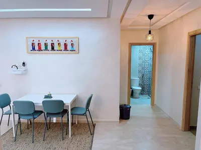 a dining room with a white table and chairs at 2BRCentral GuelizYSLMajorelle Netflix&100MBfibre in Marrakech