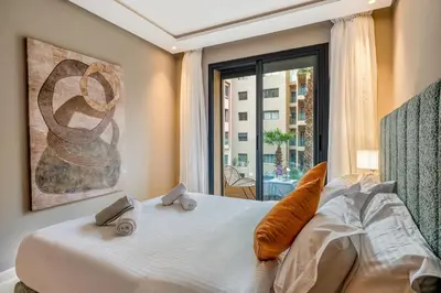 a bedroom with a large white bed with a window at Appartement Neuf et luxueux de 3 chambres proche du centre ville in Marrakech
