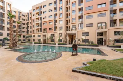 a courtyard with a fountain in front of a building at Appartement Neuf et luxueux de 3 chambres proche du centre ville in Marrakech